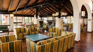 a lobby with chairs and tables in a building at Essence Isola d'Elba - Le Picchiaie Resort in Portoferraio