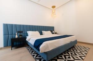 a bedroom with a large bed with a blue headboard at Calangute Heights in Calangute