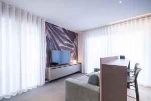 a living room with a tv and a couch and a table at A&G Elettra flat a pochi passi dal mare e Venezia in Cavallino-Treporti