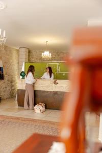 a woman standing in front of a bathroom mirror at Hotel Boutique Il Castellino Relais in Vieste +86 photos