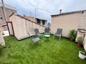 a patio with chairs and a table on the grass at Guest House Sa Succargia in Baunei