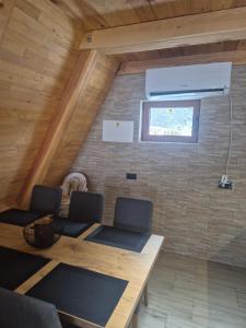 a room with a wooden table and chairs and a window at Greenland in Žabljak