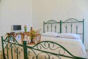 ein Schlafzimmer mit einem grünen Bett, einem Schreibtisch und einem Computer in der Unterkunft Le Sciosce in San Giorgio Lucano
