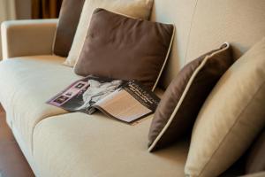 a book sitting on top of a couch with pillows at Essence Isola d'Elba - Le Picchiaie Resort in Portoferraio +72 photos