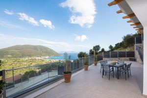 a balcony with a table and chairs and a view of the ocean at Aifantis Villa 2 in Póndi