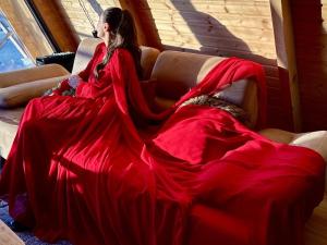 a woman in a red dress sitting on a couch at Mountain View in Goderdzi