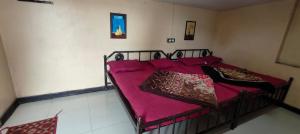 a bedroom with a bed with a red blanket at Yamuna rooms and dormitory in Ooty +7 photos