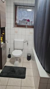 a bathroom with a toilet and a window and a tub at Moderne, ruhige Ferienwohnung! in Geistingen