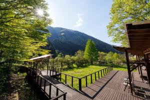 a wooden deck with a view of a mountain at Yumoto Choza in Takayama