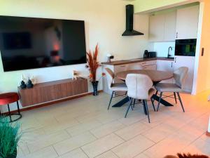 a kitchen and dining room with a table and chairs at Au delà du miroir in Stavelot