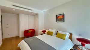 a bedroom with a bed and a red chair at Prime - Shared Pool - 6 Guests - Albufeira in Albufeira