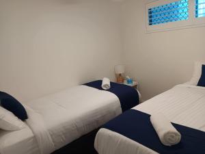 a bedroom with two beds and a window at Oceanfront Ground Floor Apartment - Dwell 3 in Bargara in Bargara