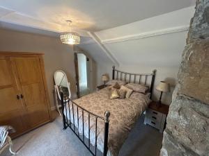 a bedroom with a bed and a chandelier at Owl Cottage - sleeps 5 near Brecon Beacons, Zip World, Bike Park Wales in Llwydcoed Station