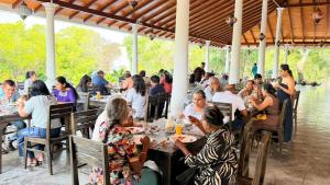 a group of people sitting at tables at a restaurant at Dutch Bay Resort & Spa in Kalpitiya