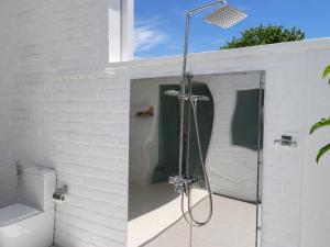 a bathroom with a shower in a white brick wall at Dutch Bay Resort & Spa in Kalpitiya +11 photos