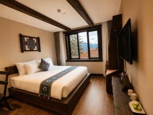 a bedroom with a bed and a television in it at The Mysteri Sapa in Sapa