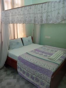 a bedroom with a bed with a canopy at La Quinta Lodge in Mwanza