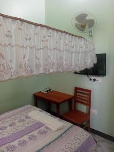a bedroom with a bed and a table and a chair at La Quinta Lodge in Mwanza