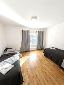 a bedroom with two beds and a wooden floor at Reipas Ekonom Accommodation in Kotka