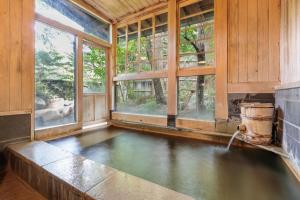 a house with a pool of water in a room with windows at Yumoto Choza in Takayama