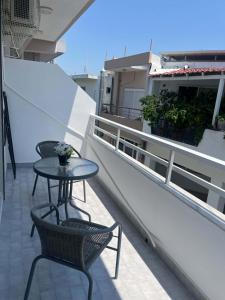 a patio with two tables and chairs on a balcony at Studio Nefeli - Heart of Archangelos in Archangelos