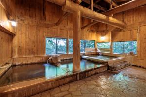 an indoor pool in a wooden building with windows at Yumoto Choza in Takayama