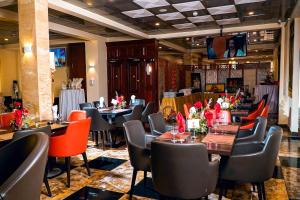 a restaurant with tables and chairs in a room at New Heaven Hôtel in Yaoundé