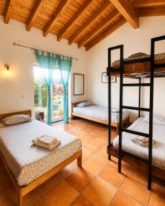 a bedroom with two bunk beds and a window at Mayla Surf House in Aljezur