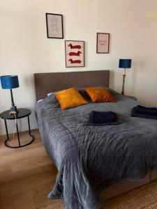 a bed in a bedroom with two lamps and a table at Logement Sylroede in Lemmer