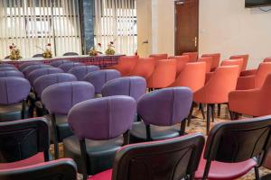 a row of chairs with purple and orange chairs at New Heaven Hôtel in Yaoundé