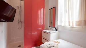 a red bathroom with a sink and a shower at chic&basic Tallers Hostal in Barcelona +15 photos