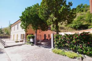 a house with a tree and a fence at I due cipressi in Cagli