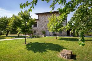 an old stone house with trees in the yard at Massoni Wine Relais in Peschiera del Garda +38 photos