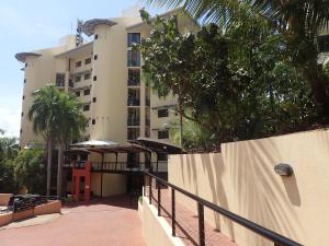 a building with a fence and trees in front of it at Darwin Deluxe Apartments in Darwin
