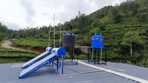 a slide on top of a roof with a mountain at Steep Valley Resort in Kotagiri