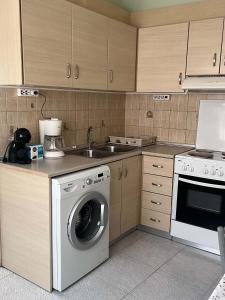 a kitchen with a washing machine and a sink at Studio Nefeli - Heart of Archangelos in Archangelos