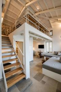 a loft conversion with a staircase and a living room at Calais Boutique Apartments in Hydra