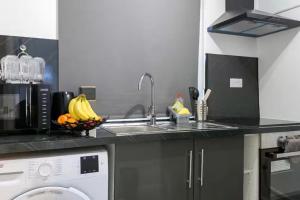 a kitchen with a sink and a washing machine at Studio - Sleeps 2 - 5 Min to Trains - Parking in Thornton Heath +3 photos