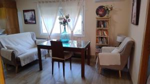 a living room with a table with a vase of flowers on it at Alojamiento a 25km de Madrid apta para mascotas cerca de zonas de ocio in Navalcarnero