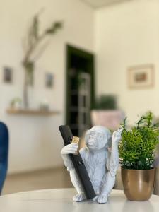 Eine kleine Statue eines Mannes, der auf einem Tisch neben einer Pflanze sitzt. in der Unterkunft BrameL Suite in Lamezia Terme