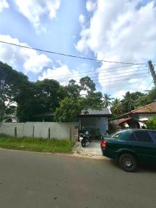 a green car parked on the side of a street at Lake Hostel Anuradhapura in Anuradhapura +9 photos