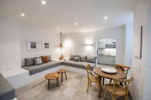 a living room with a couch and a table and chairs at Calais Boutique Apartments in Hydra
