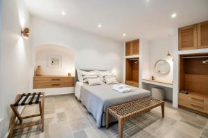 a bedroom with a bed and a table and a chair at Calais Boutique Apartments in Hydra