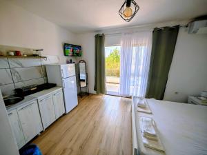 a kitchen with a refrigerator and a sink and a window at White apartments in Ulcinj