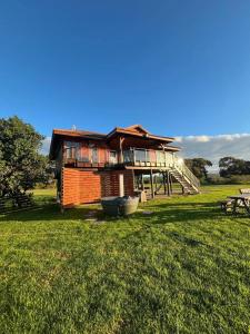 a wooden house with a porch on a grass field at Rivers End Farm Stanford - Cabins in Stanford