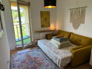 a living room with a couch and a window at Rooms in an Apartment with Beautiful Views in Przemyśl