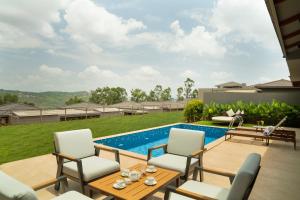 a patio with a table and chairs and a swimming pool at Ayati Resort & Spa in Panchgani