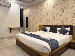 a bedroom with a large bed with blue and white pillows at Sunburry Hotel Khatu 700mts from Temple in Khātu +3 photos