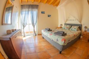 a bedroom with a bed and a large window at Mayla Surf House in Aljezur