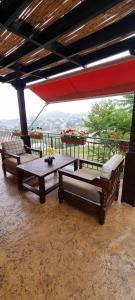a patio with two chairs and a table and an umbrella at Maison des Couleurs in Aley